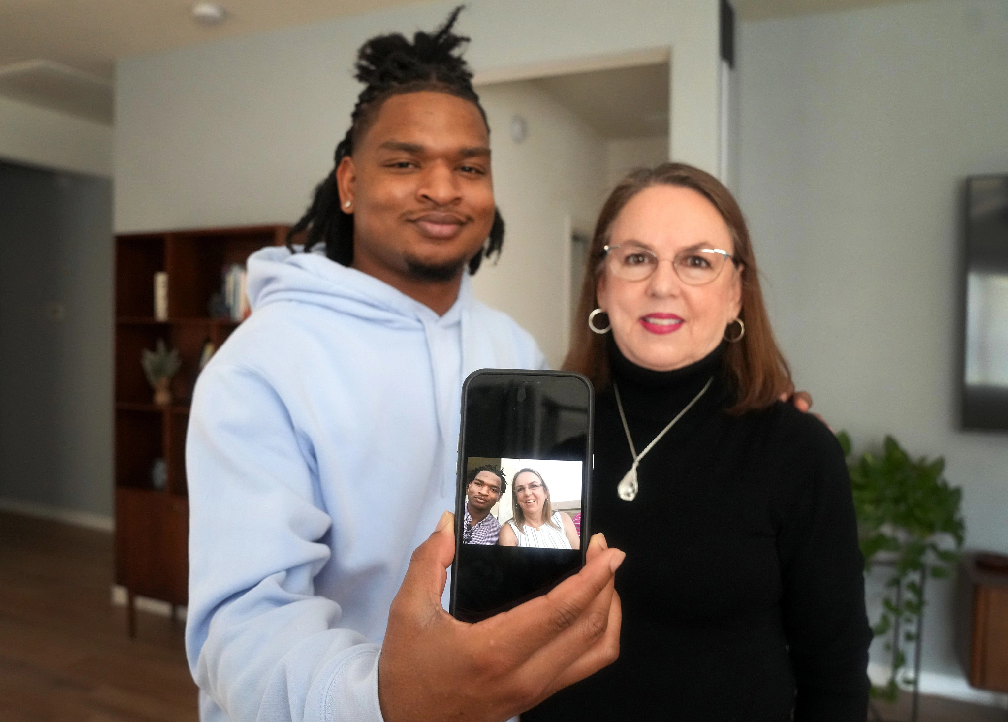 A photo shows Jalal Hinton and Wanda Dench showing off a selfie on a smartphone