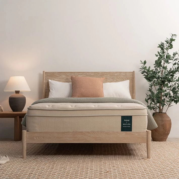 The Leesa Natural Hybrid on a light wooden bed frame
