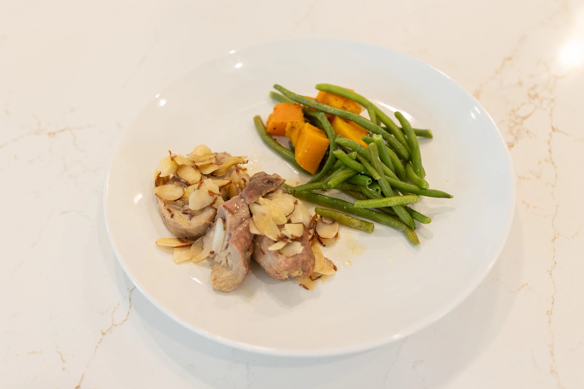Dijon mustard pork with green beans meal from Trifecta on a white plate