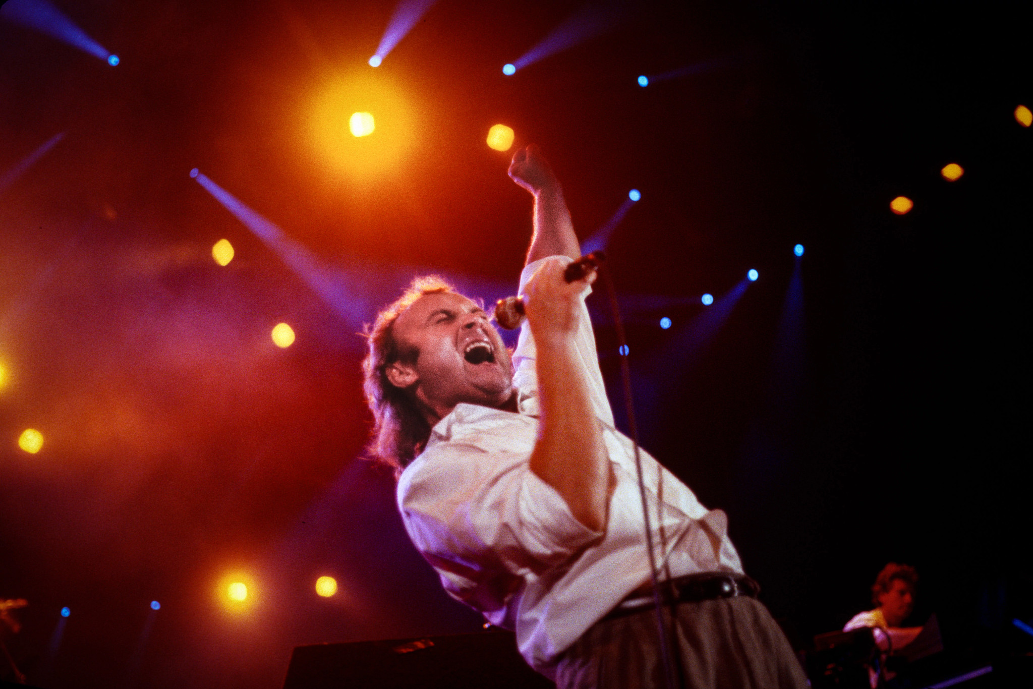 phil collins performing onstage in 1987