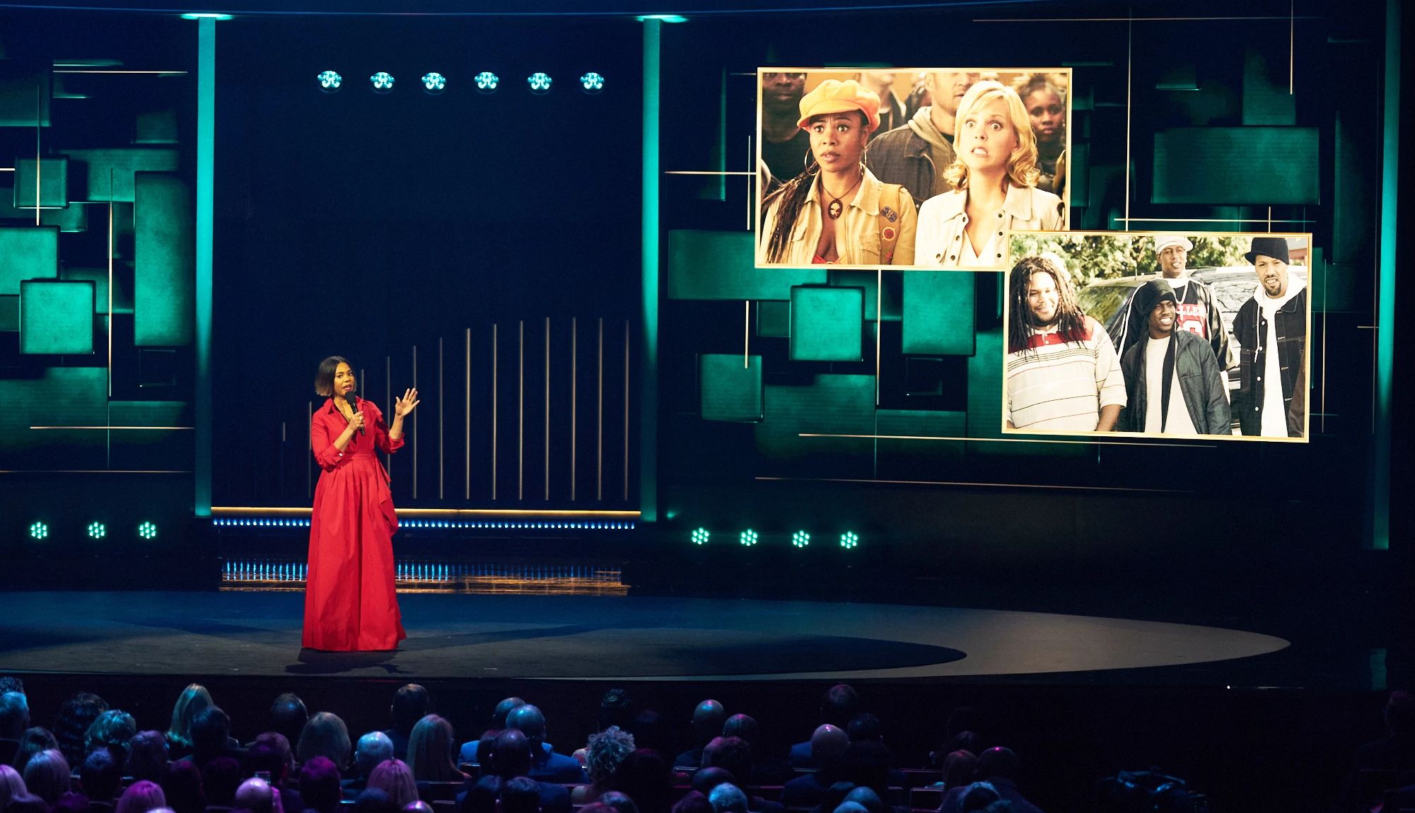 Regina Hall onstage with images of him and Kevin Hart is projected on a big monitor in the background at the 25th Annual Mark Twain Prize For American Humor