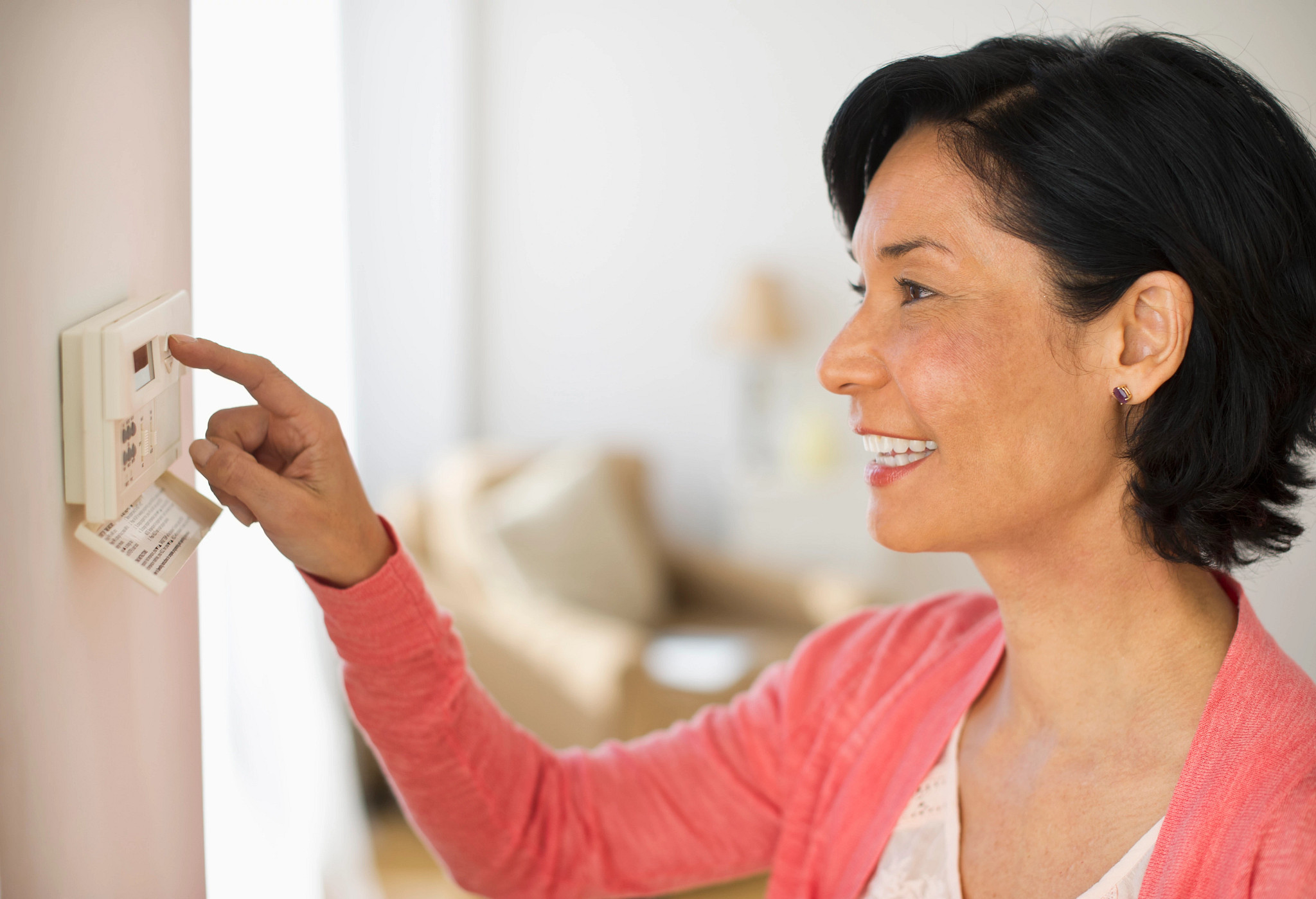 Mature woman adjusting room temperature