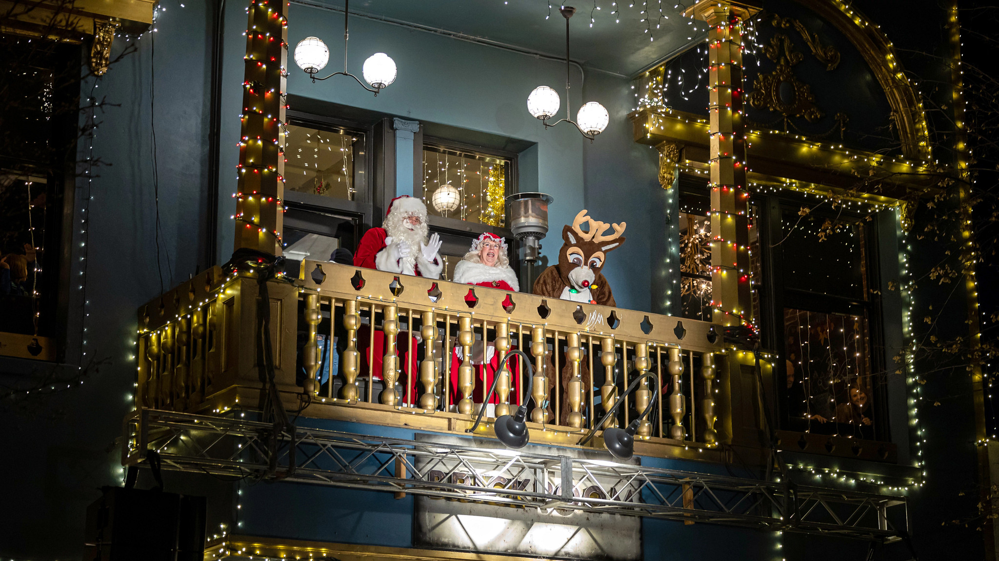 santa, mrs claus and rudolph the red nose reindeer on a balcony