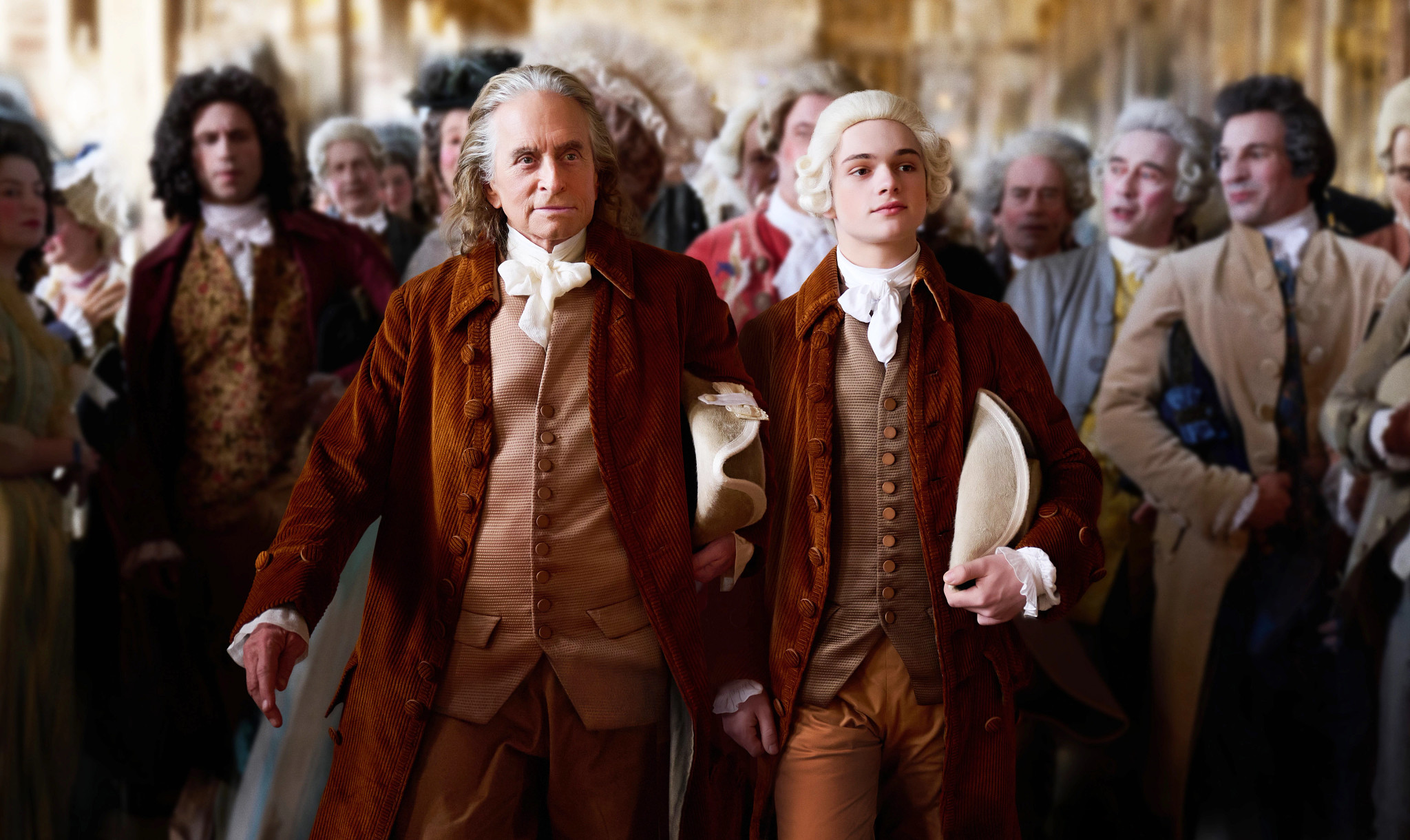 Michael Douglas and Noah Jupe walking together in a scene in the Apple TV Plus series Franklin