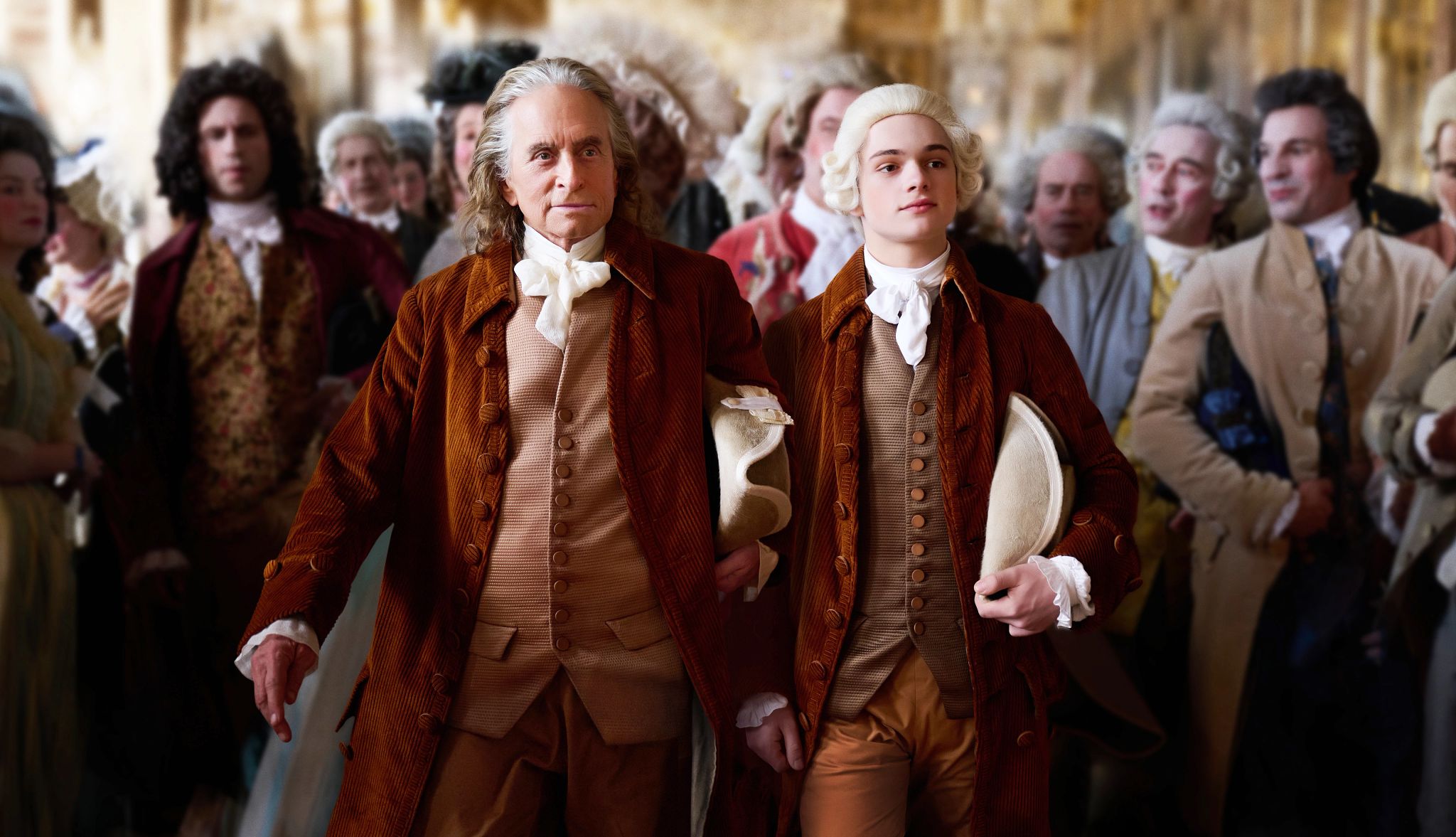 Michael Douglas and Noah Jupe walking together in a scene in the Apple TV Plus series Franklin