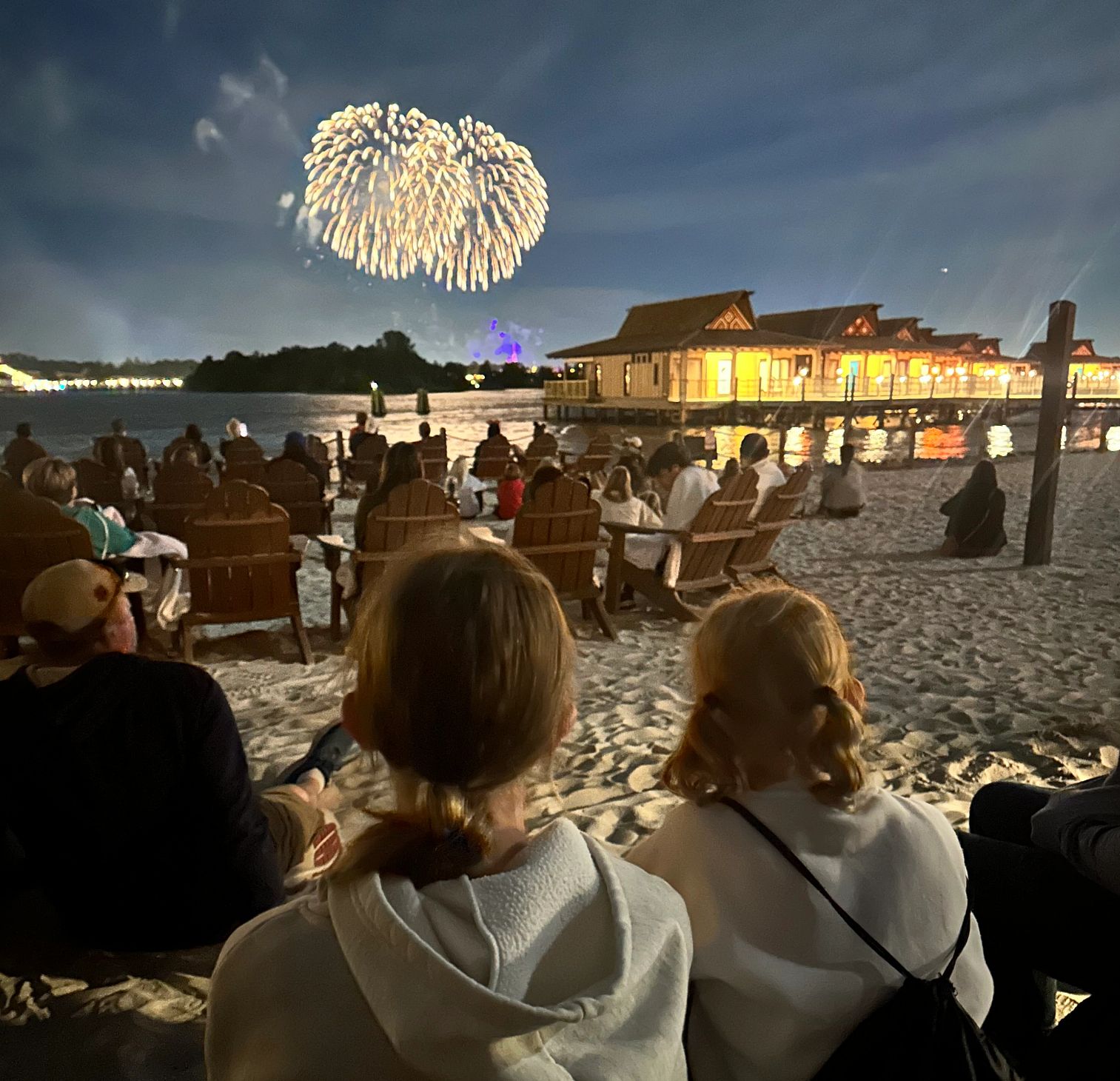 Bucket List Beach Experiences spectators watch from a beach as fireworks are set off at disney world