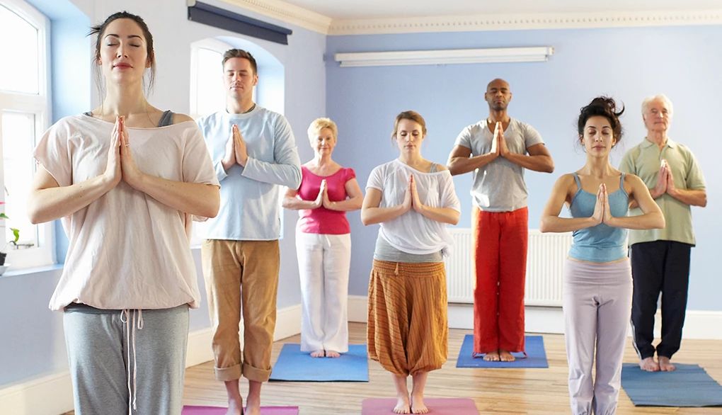 Guided meditations may help you find your calm A group of people standing on yoga mats and meditating