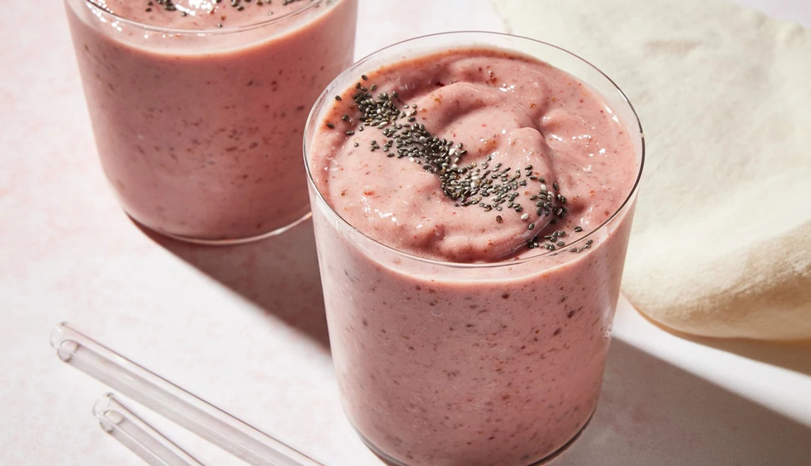 A close-up view of two strawberry-peach chia seed smoothies