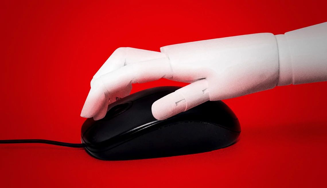 una mano de un robot haciendo clic en un ratón de computadora
