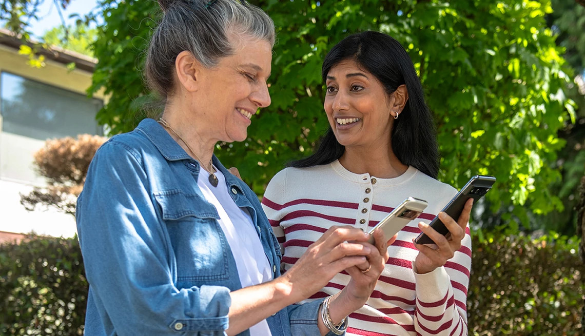 Two women laughing and holding cell phones