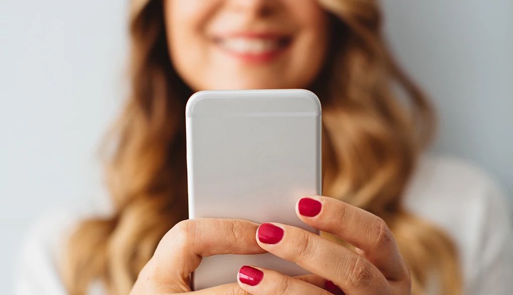 Talking with a buddy can help strengthen your friend network A woman holding up her cell phone out in front of her
