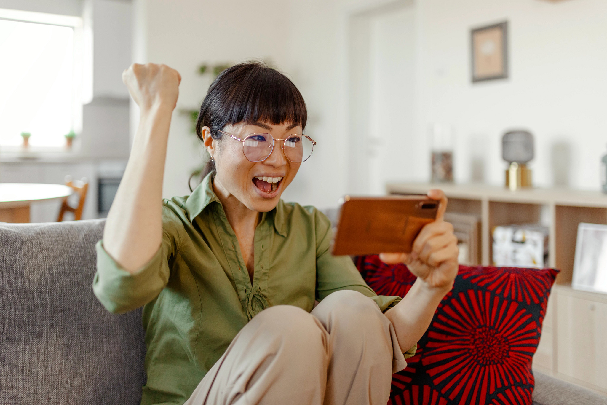 Women excited while viewing smartphone.