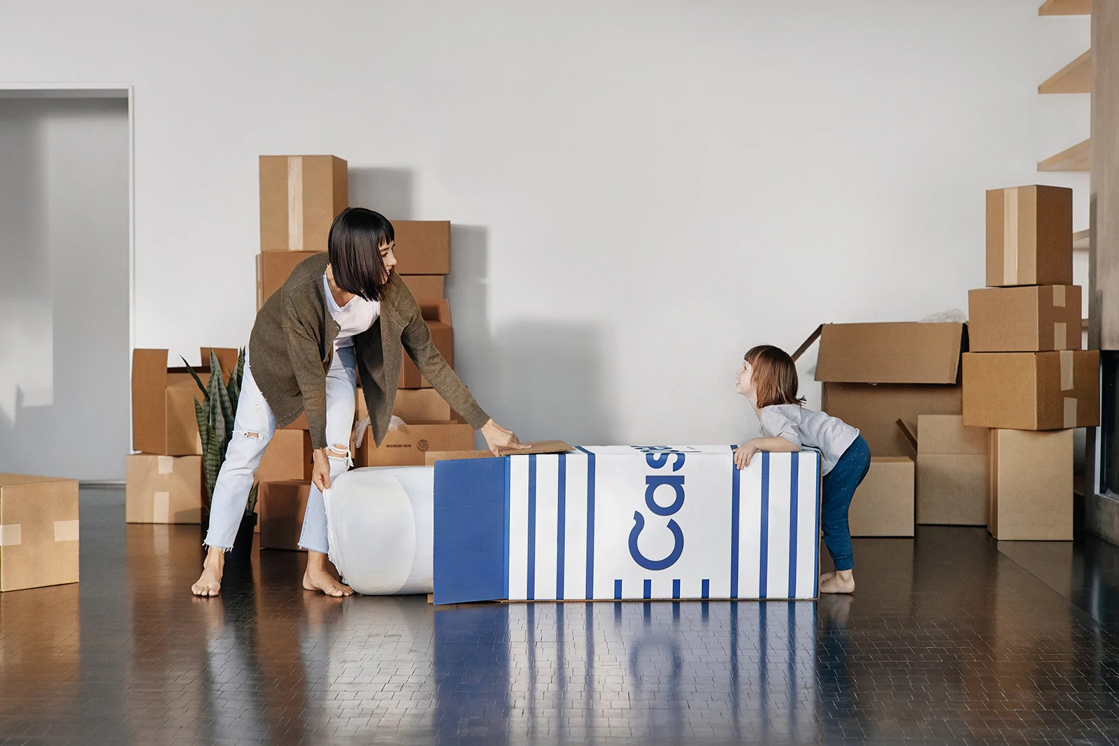 mother and daughter opening casper mattress box at home
