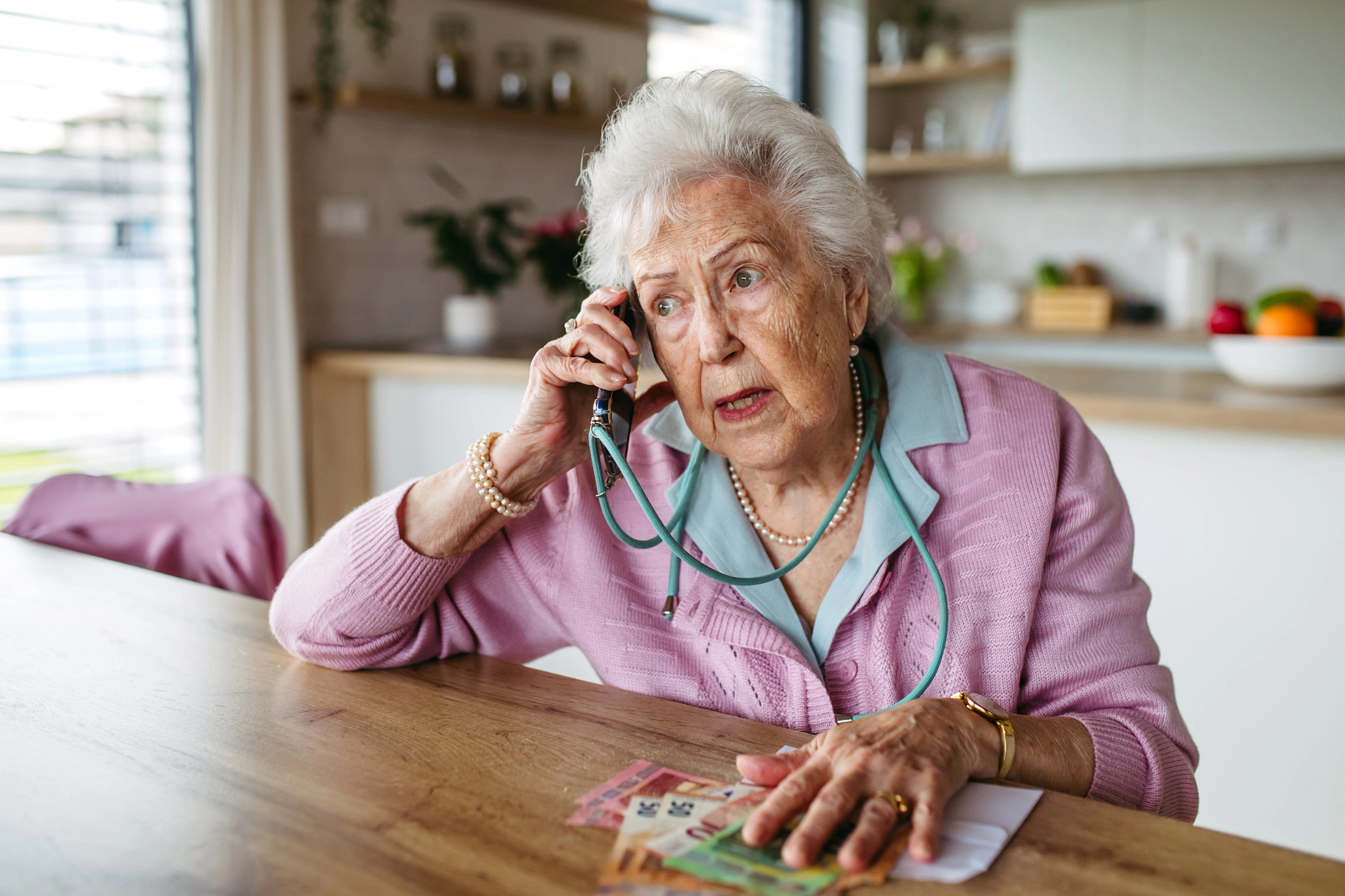 Scammer making phone call with elderly woman, asking for money, demanding personal, sensitive informations over phone without verification.
