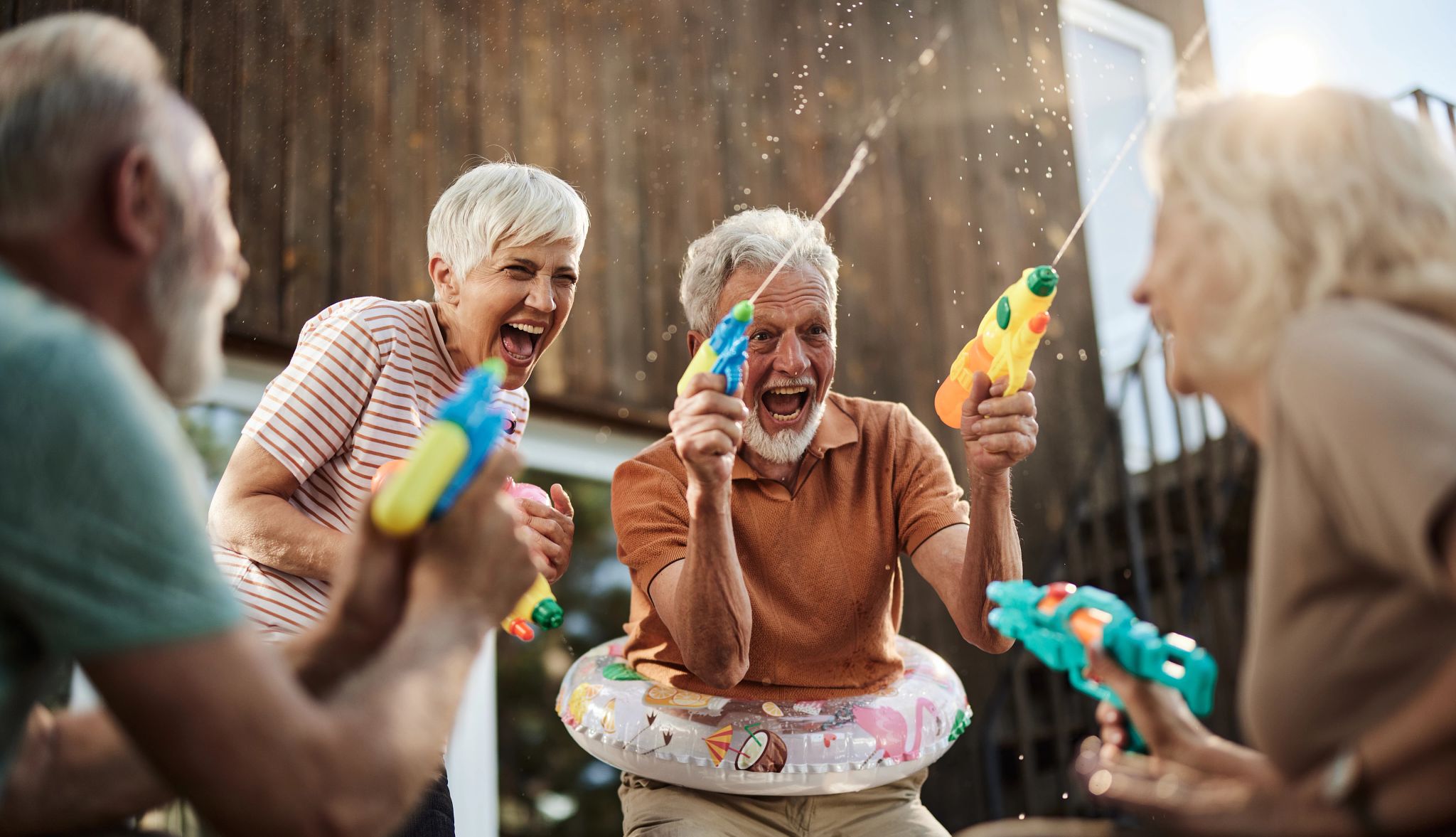 Having fun A group of older adults having fun playing with water guns