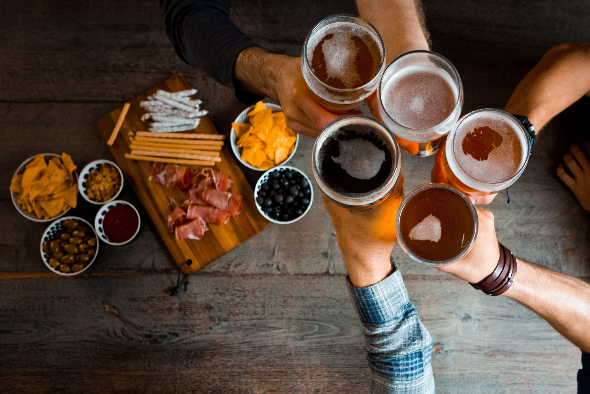a group of people cheersing beers 
