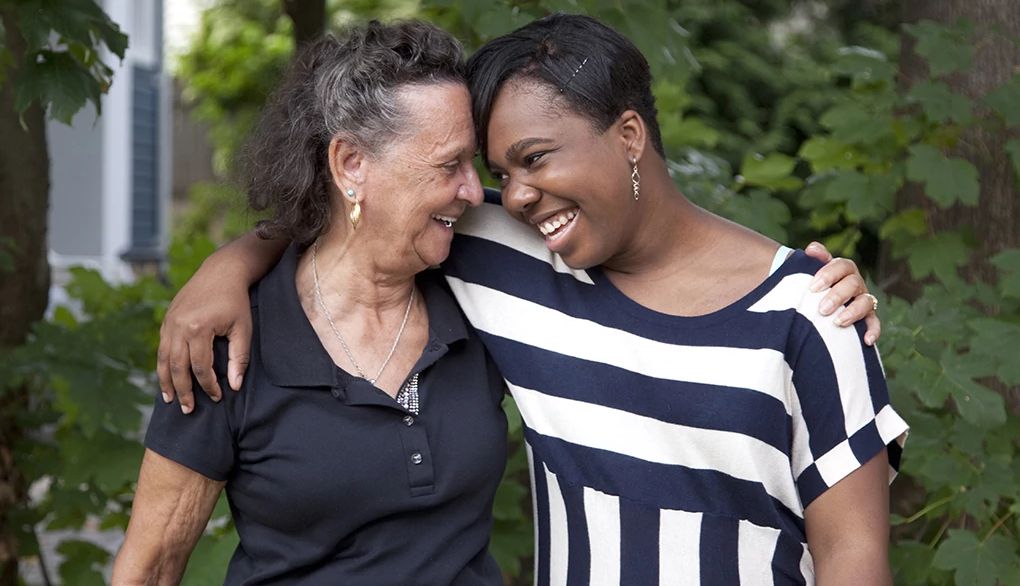 Reminiscing with loved ones can deepen your relationships Two women smiling and hugging each other