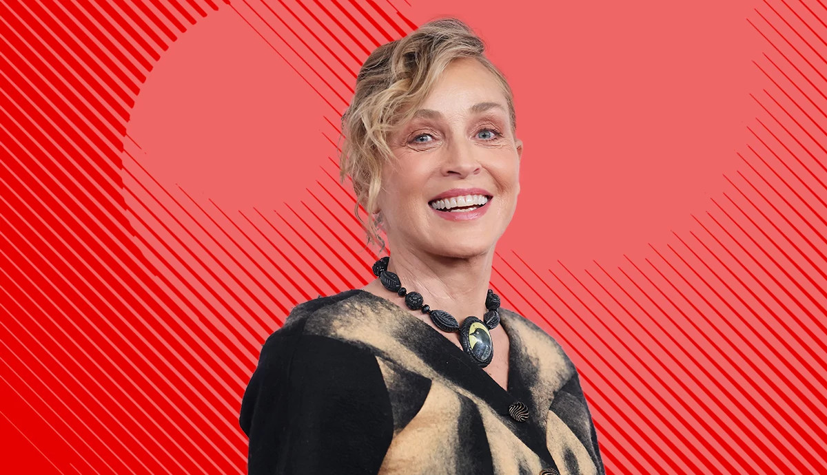 sharon stone smiling in front of a patterned red background