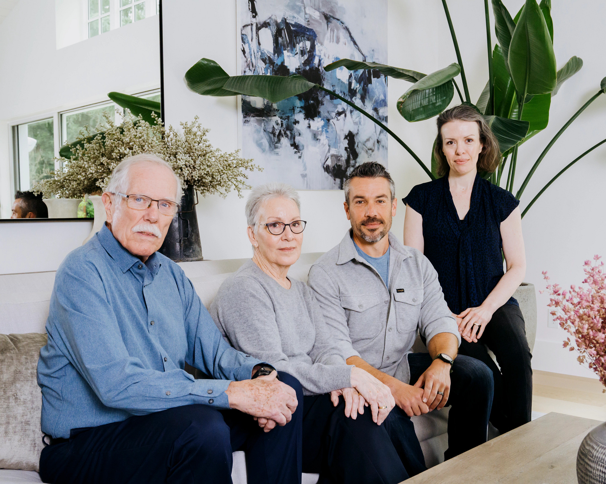 four people posing for a picture on a couch