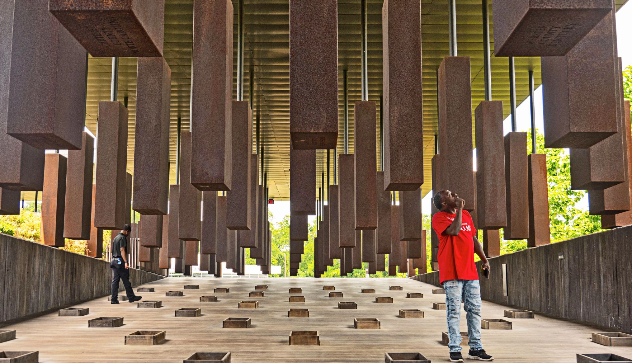 The National Memorial for Peace and Justice opened in 2018 two men observing the steel monuments