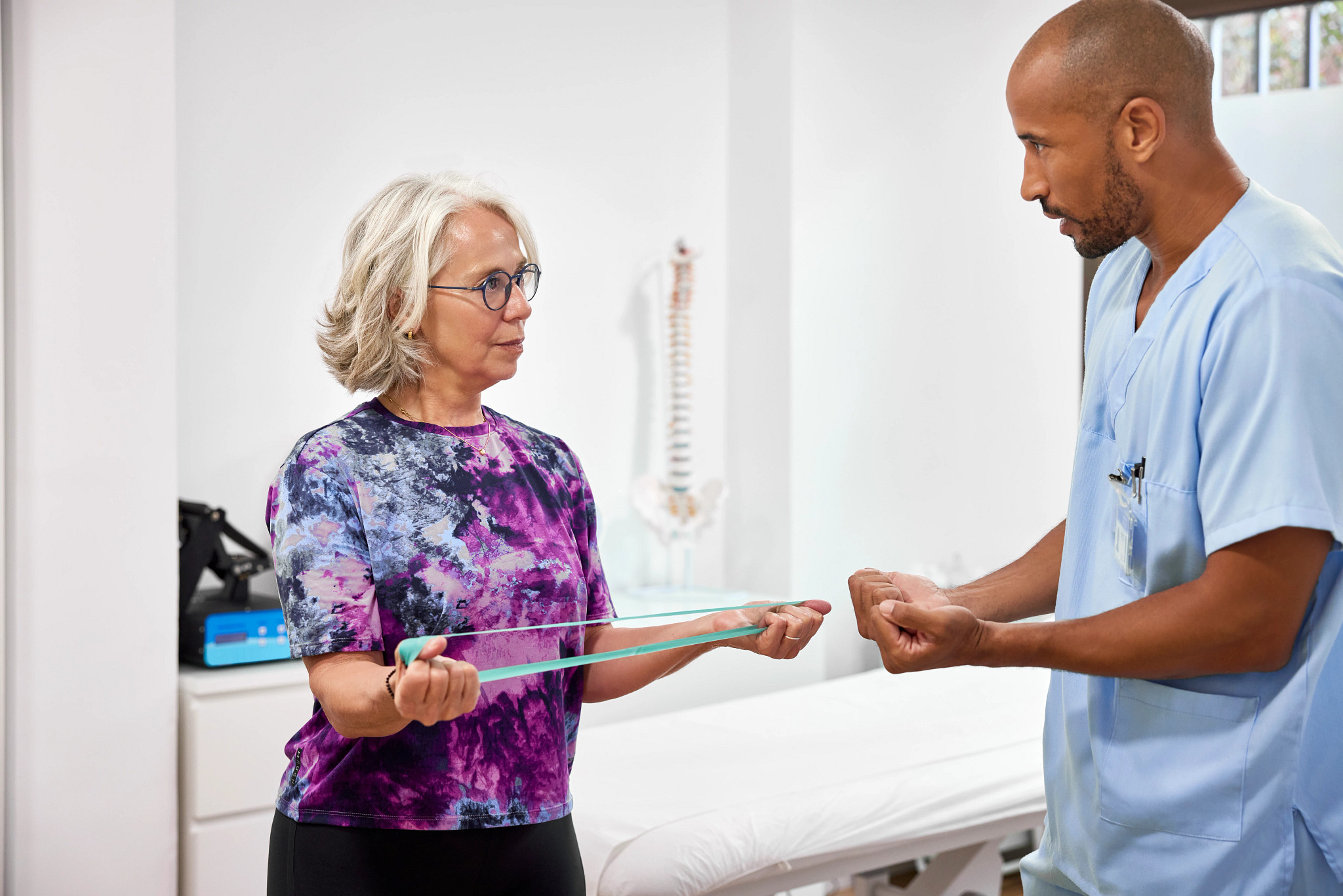 a woman holding a band while talking to a nurse
