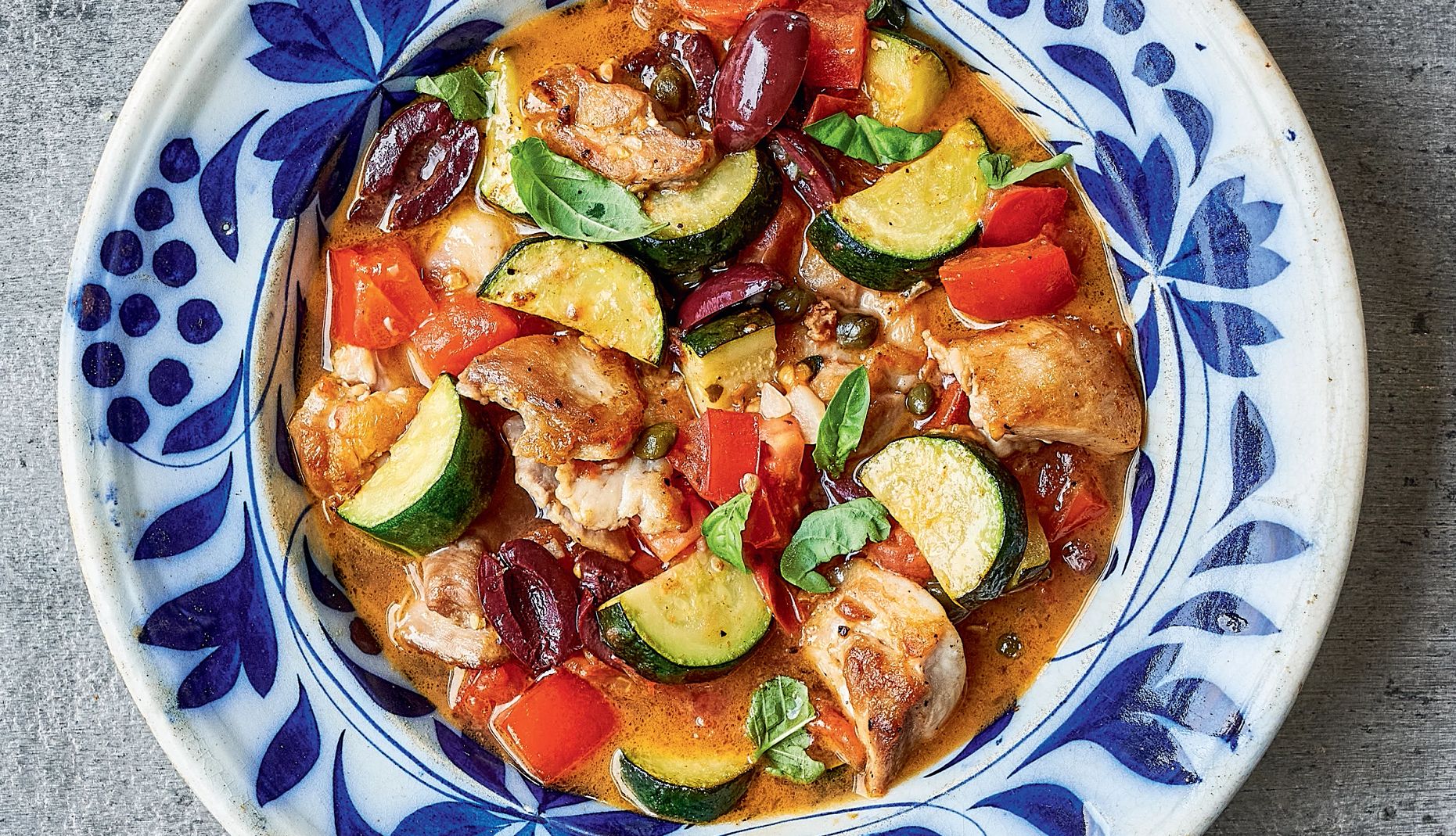 Provençal chicken Stew made of chicken, olives, capers, garlic, zucchini and tomatoes in a bowl