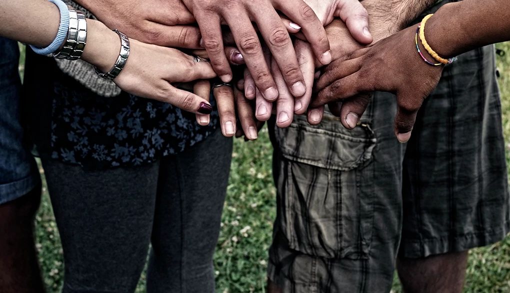 Volunteering later in life may help to protect the brain An up-close view of several hands touching each other