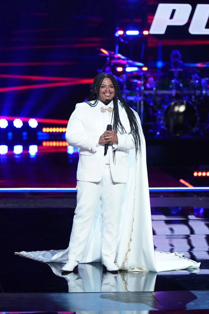 The Voice contestant Asher HaVon smiling onstage holding a microphone during the Pretaped Playoffs