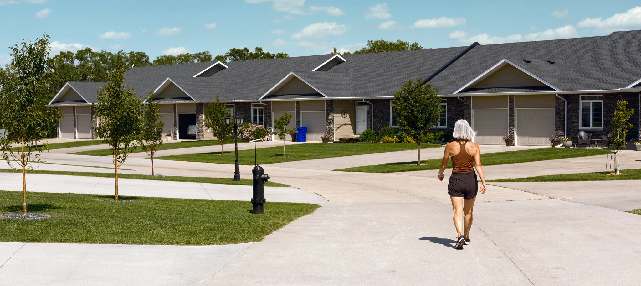 Una mujer mayor dando un paseo alrededor del complejo de condominios