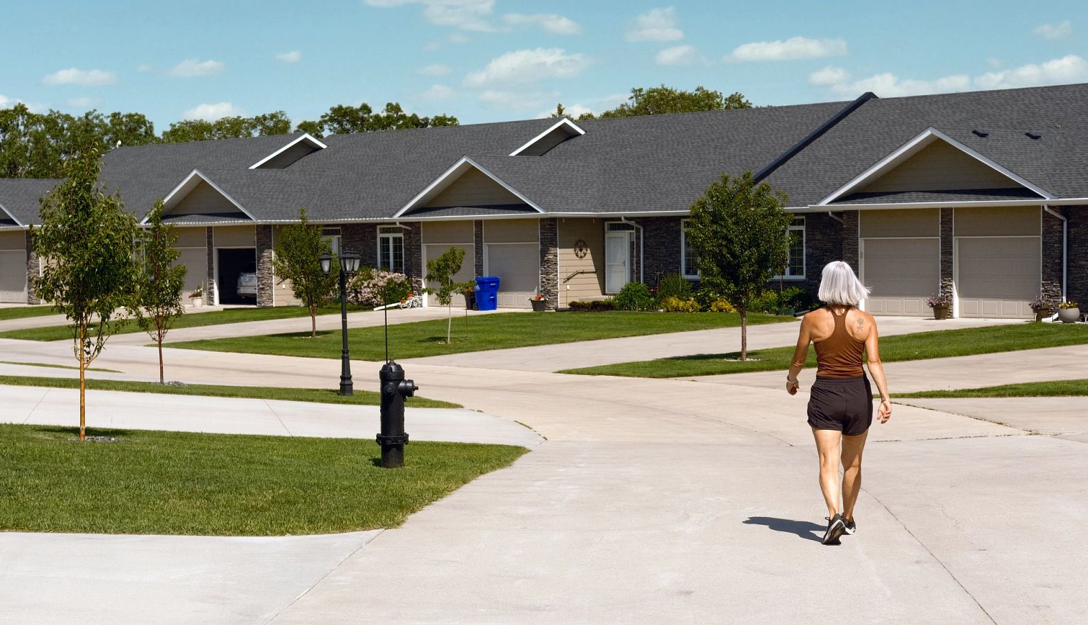 Una mujer mayor dando un paseo alrededor del complejo de condominios