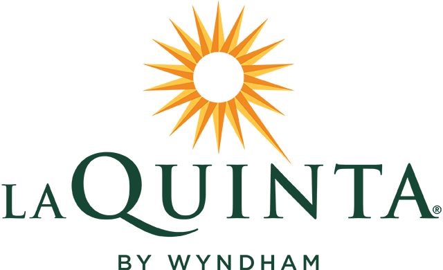 La Quinta by Wyndham white circle with yellow spikes around it black letters la quinta by wyndham