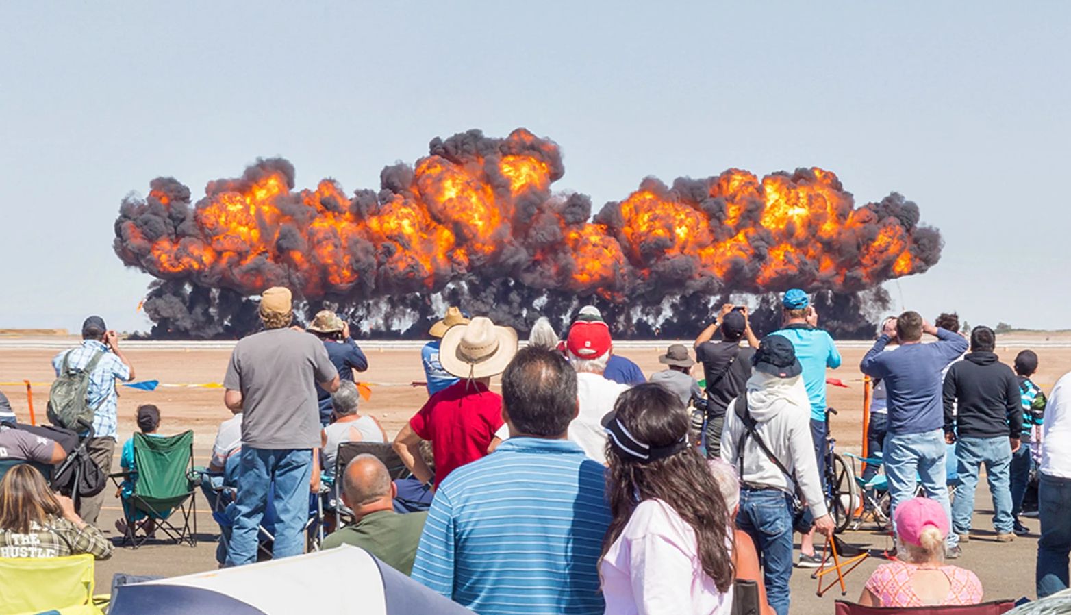 Blue Angels a crowd watches clouds of smoke and fire
