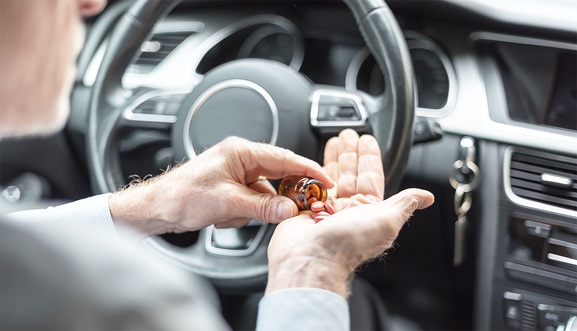 Taking Medicine and Driving taking a handful of pills behind the wheel
