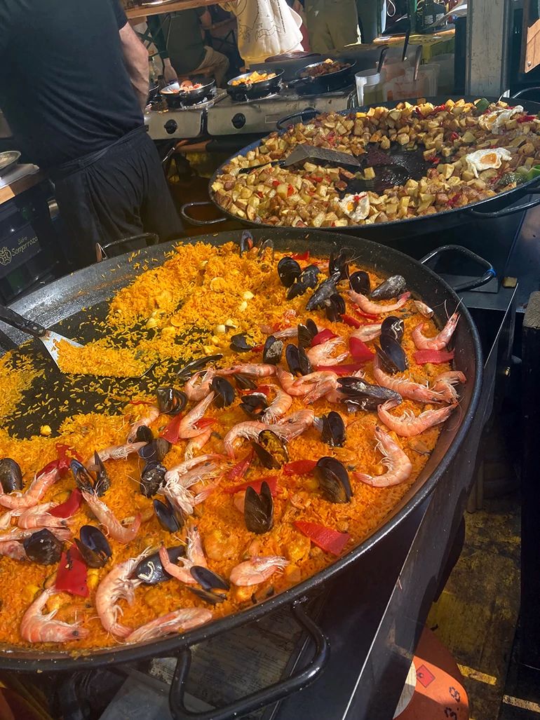 Spainish food in pans food in two large frying pans on a stove