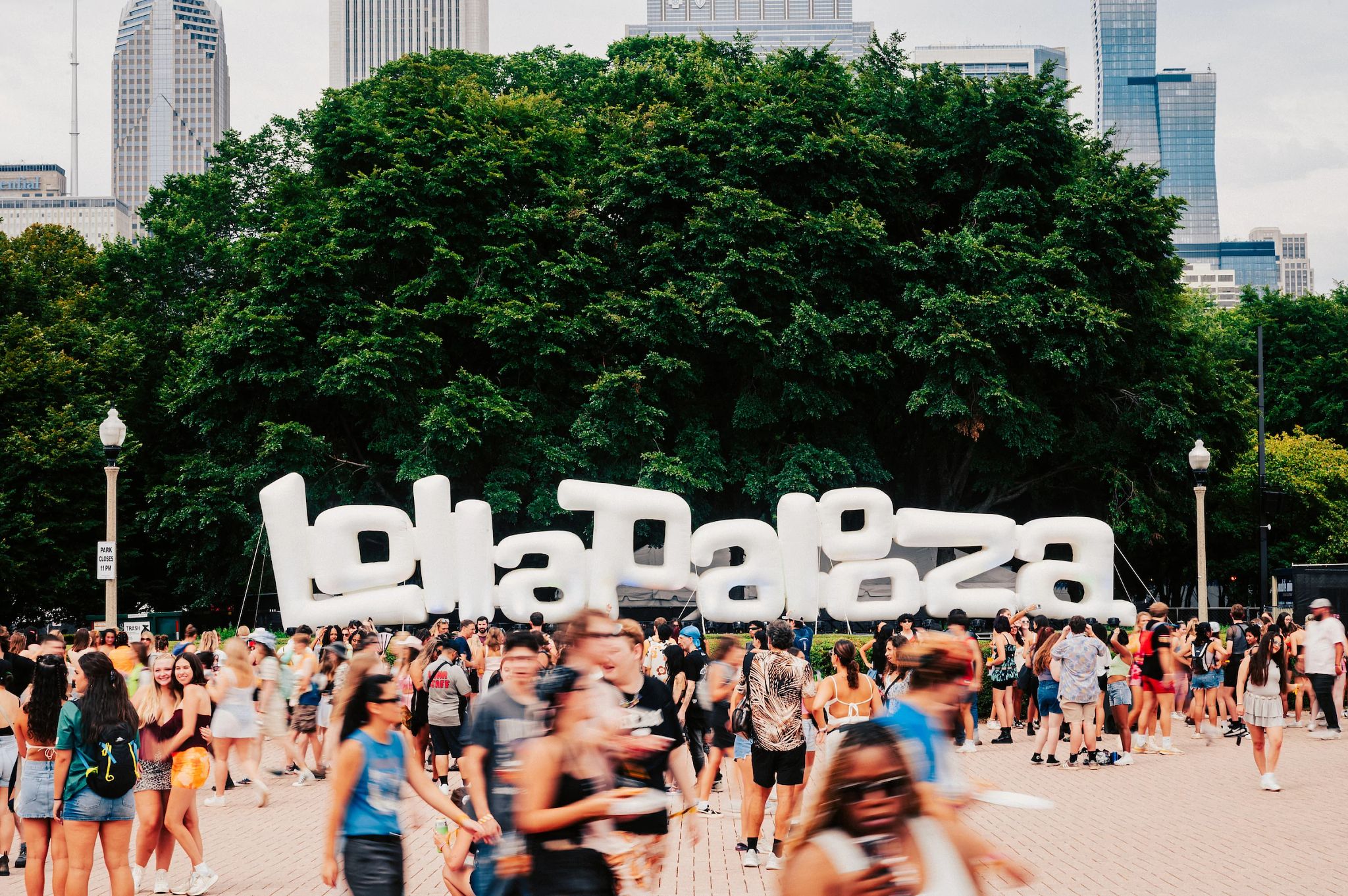 Two Generations Take in Lollapalooza Together Big lollapalooza sign with a bunch of people in front of it