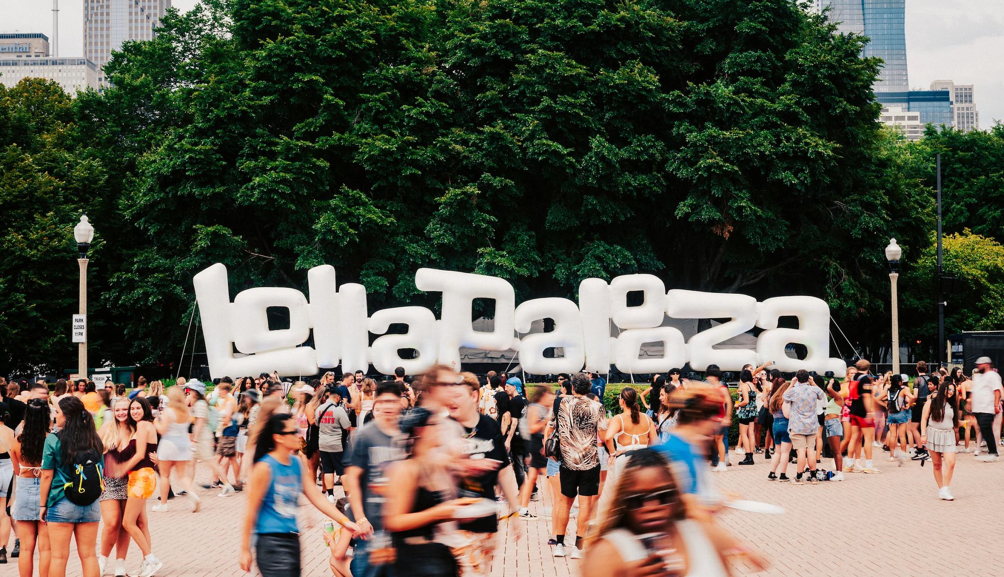 Two Generations Take in Lollapalooza Together Big lollapalooza sign with a bunch of people in front of it