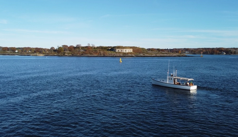 Fall Foliage Activities a small boat on a body of water with a shoreline in the distance