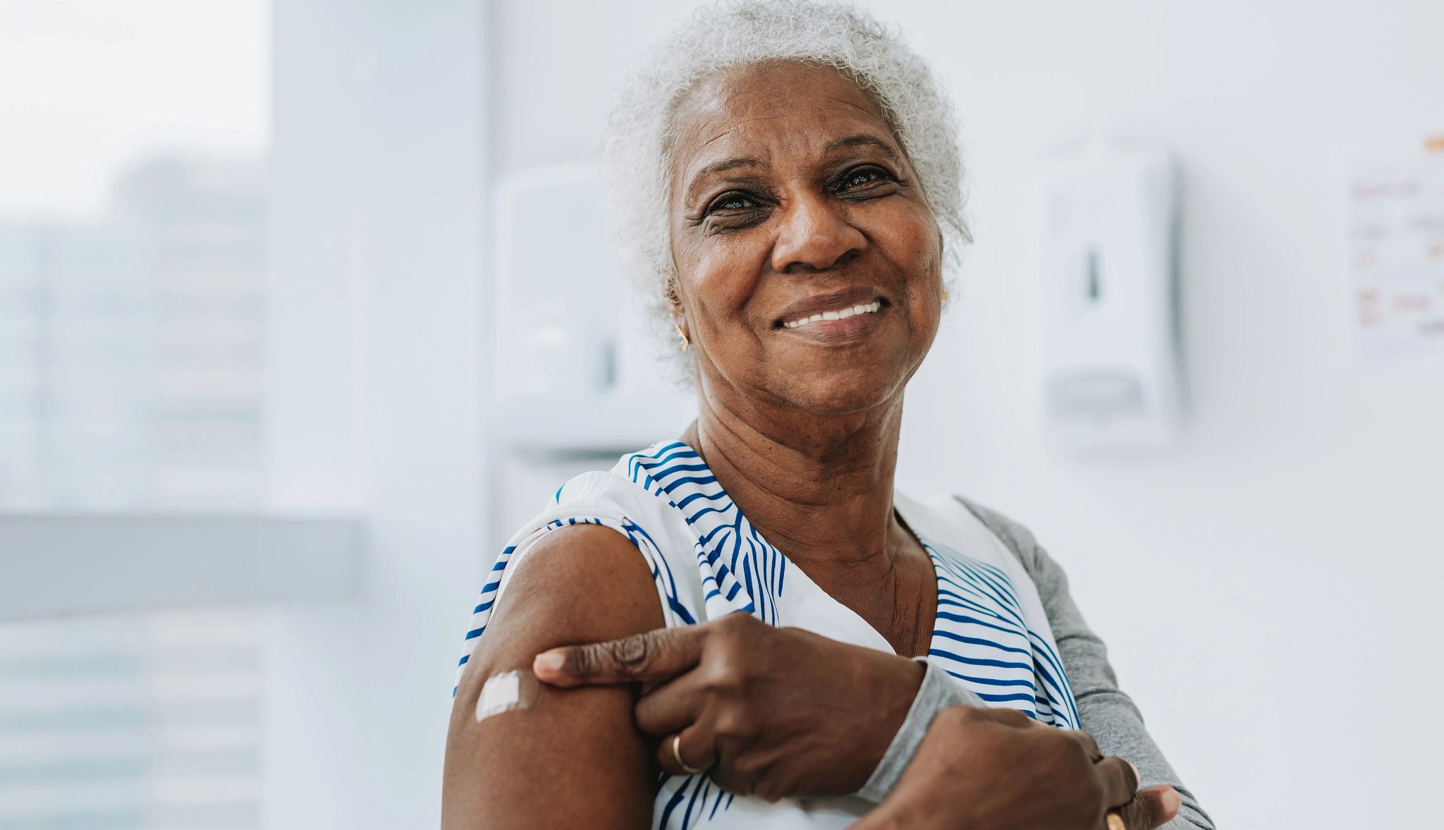 Portrait of a senior woman showing that she has been immunized with the vaccine