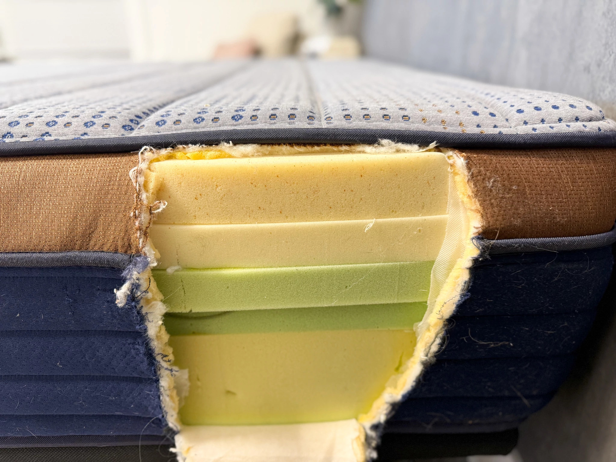 Hole cut in the side of a mattress shows five distinct layers of memory foam