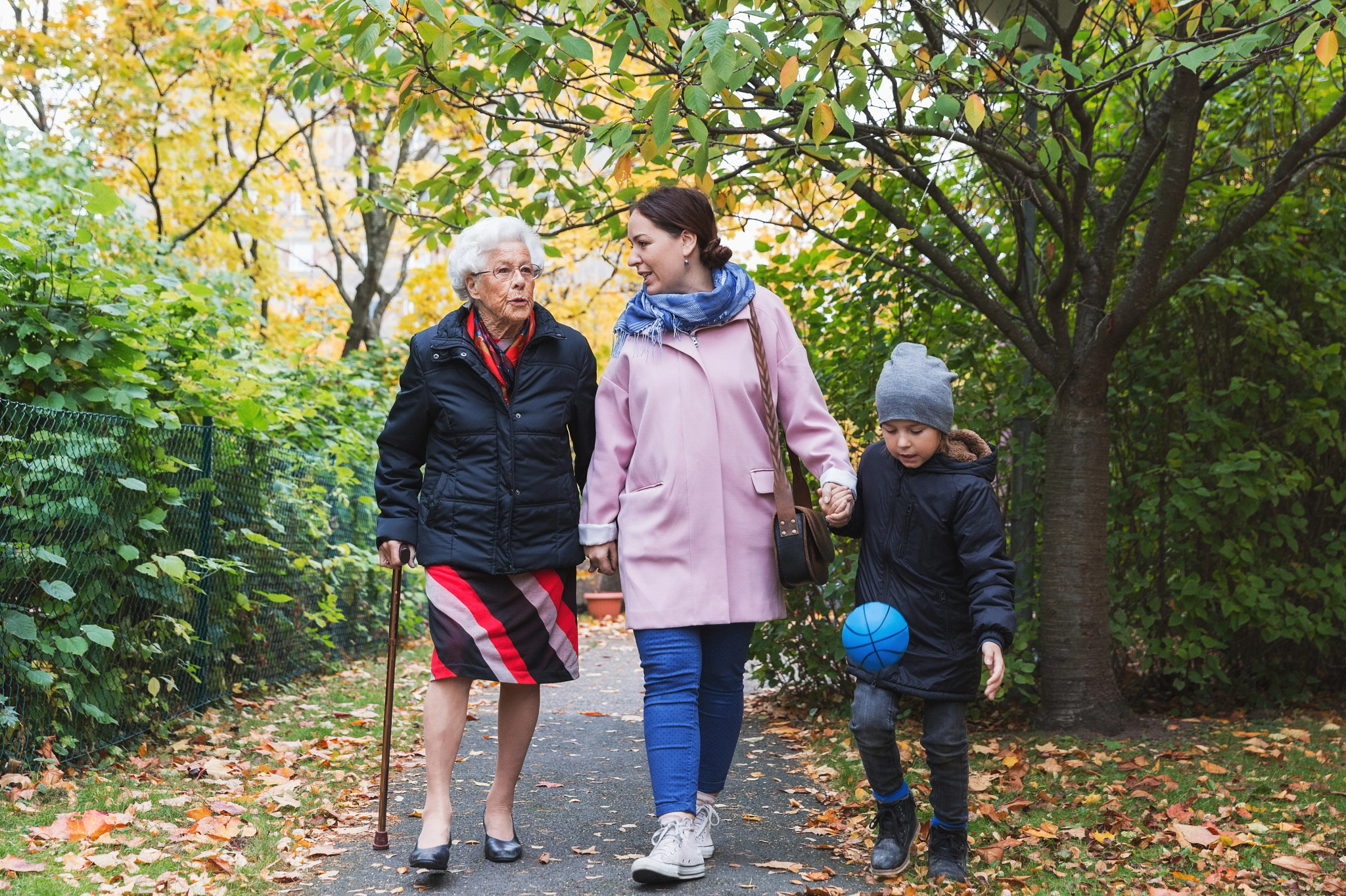 Full length of senior woman walking with daughter and great grandson in park