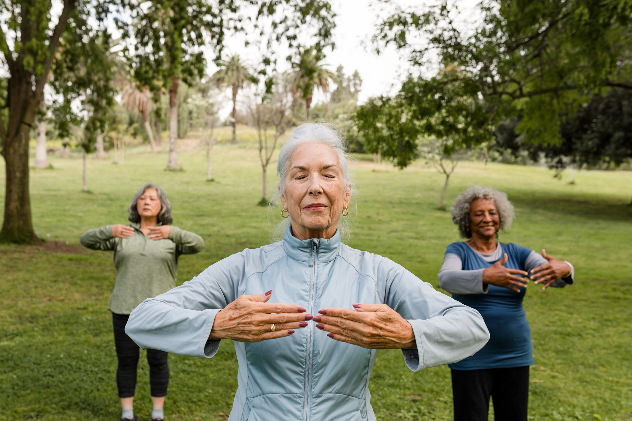 Three women practicing yoga in a park