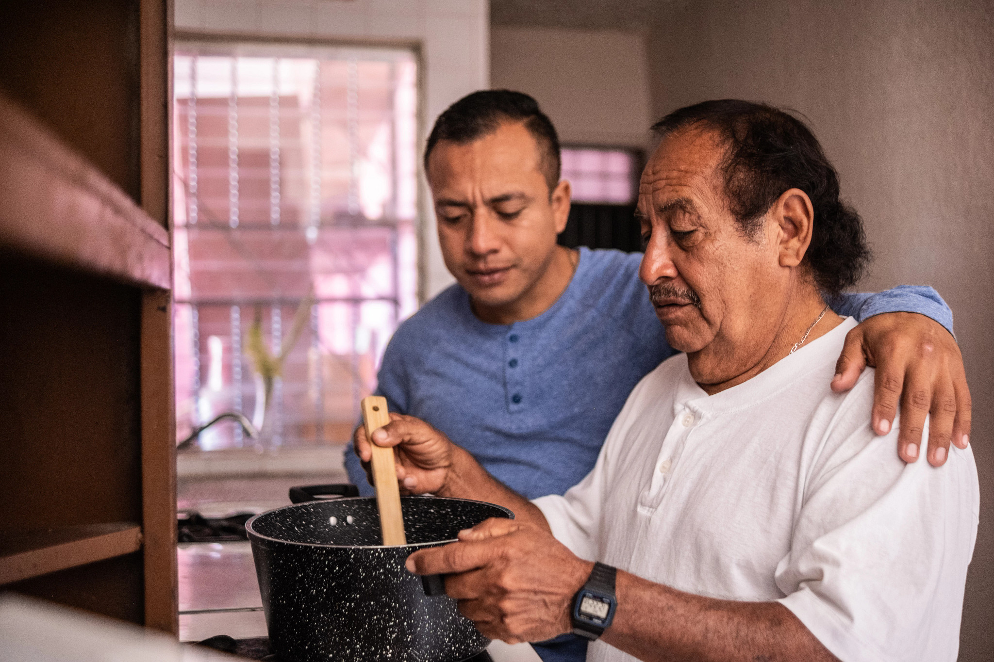 Portrait of a Latin father and son cooking at home