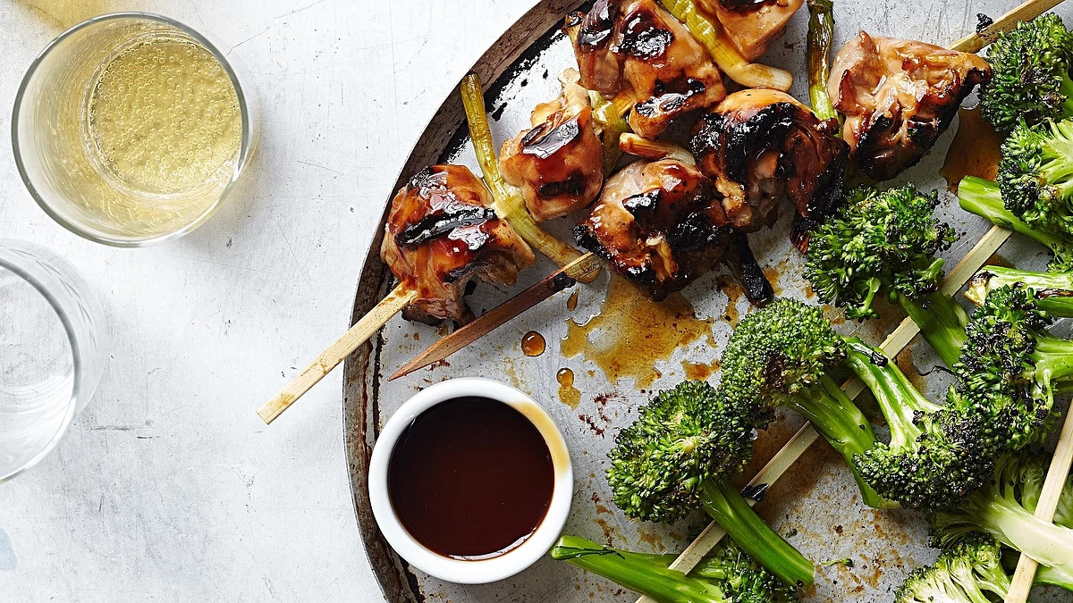 A close-up view of chicken yakitori with broccoli on a plate