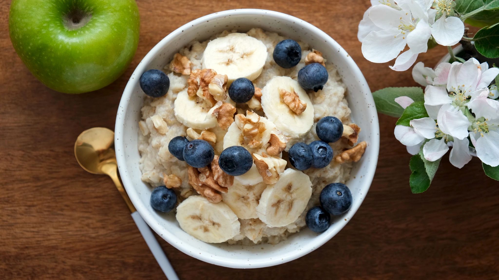 Bowl of oatmeal porridge with banana, blueberry, walnuts