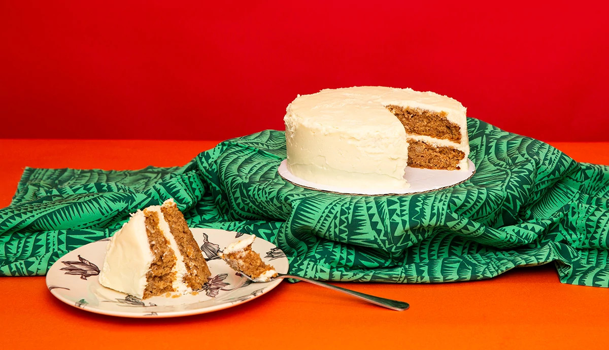 A Mortgage Apple Cake on a green blanket with orange background, featured in Sisters From AARP sweepstakes.