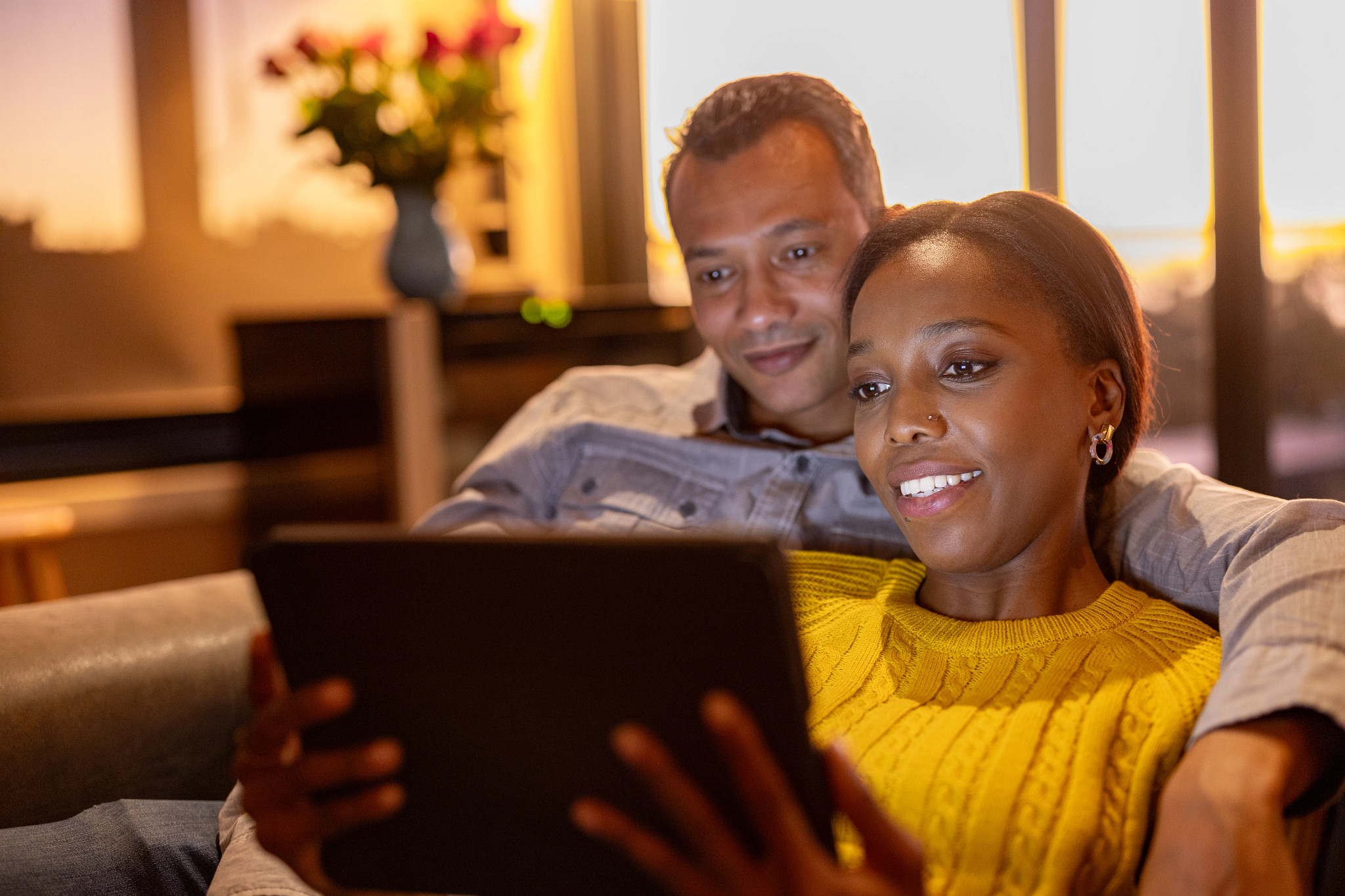 Couple on a video call to friends on their sofa