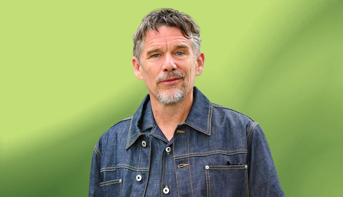 Ethan Hawke Is Cool With Aging ethan hawke posing for a portrait in front of a green background