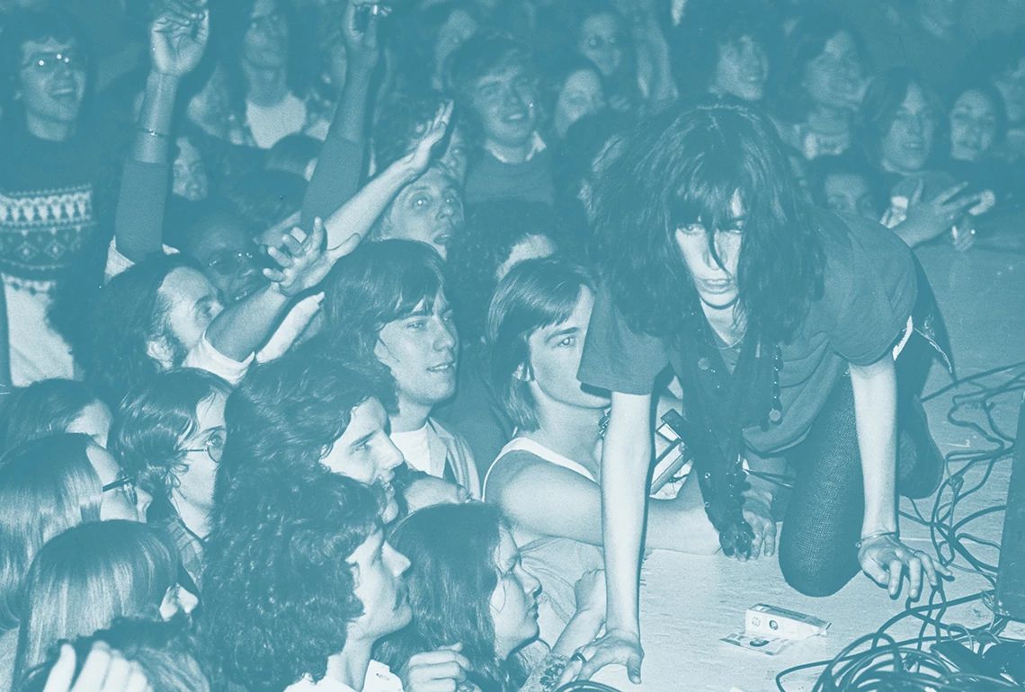 Patti Smith crawling onstage with the audience watching