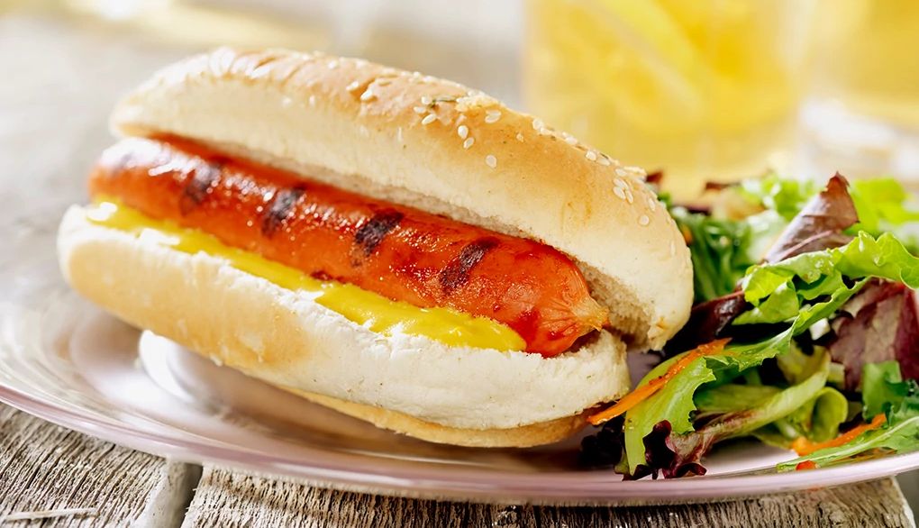 Make better health choices when eating fast food A close-up view of a hot dog and salad on a plate