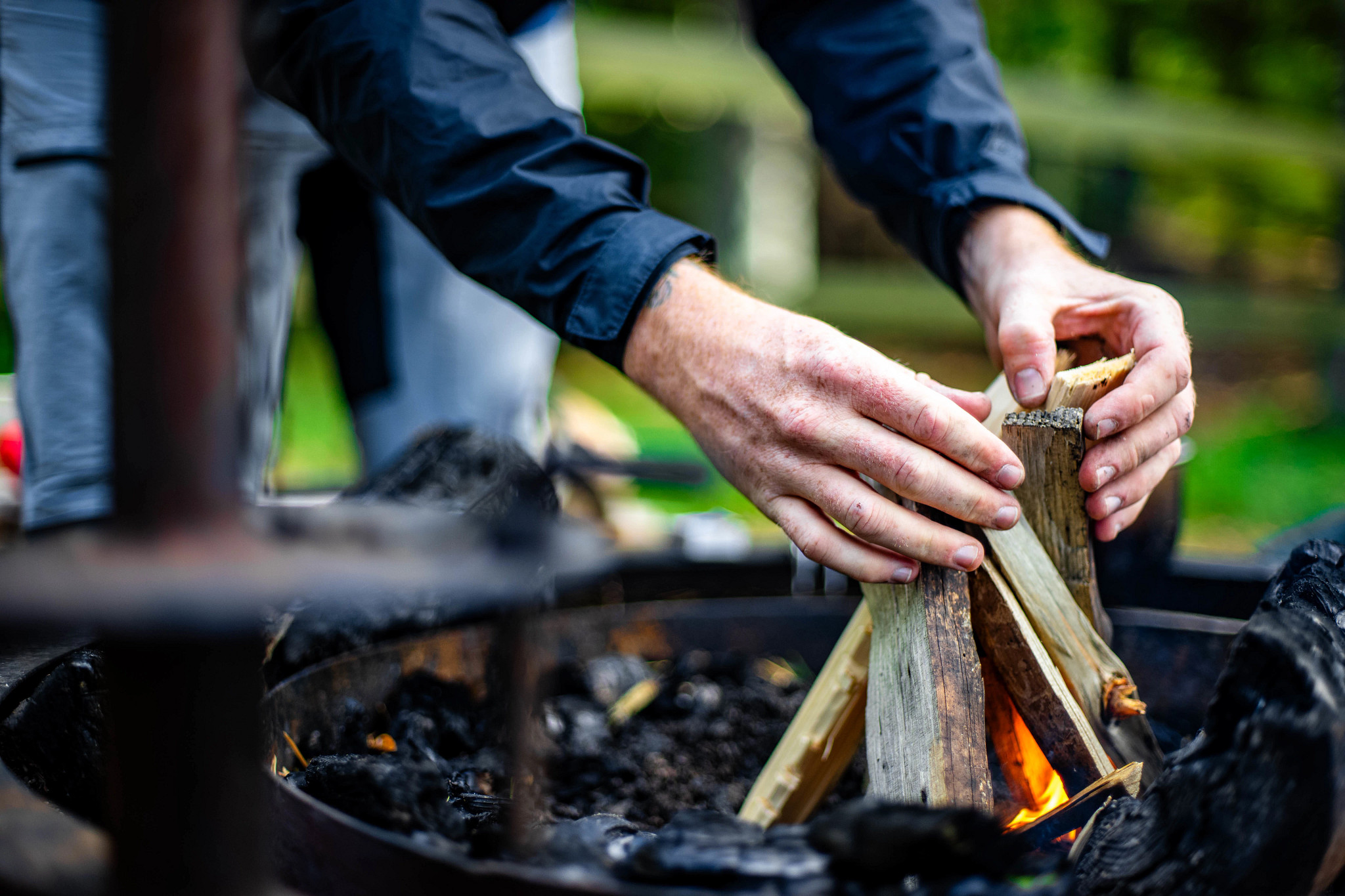a person building a fire in a pit